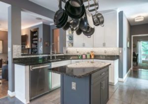 A newly renovated kitchen with updated cabinetry, new countertops, and unique storage for pots and pans